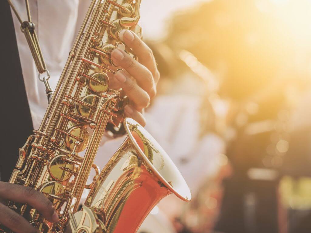 A picture of a saxaphone at a jazz festival illuminate by golden sunlight