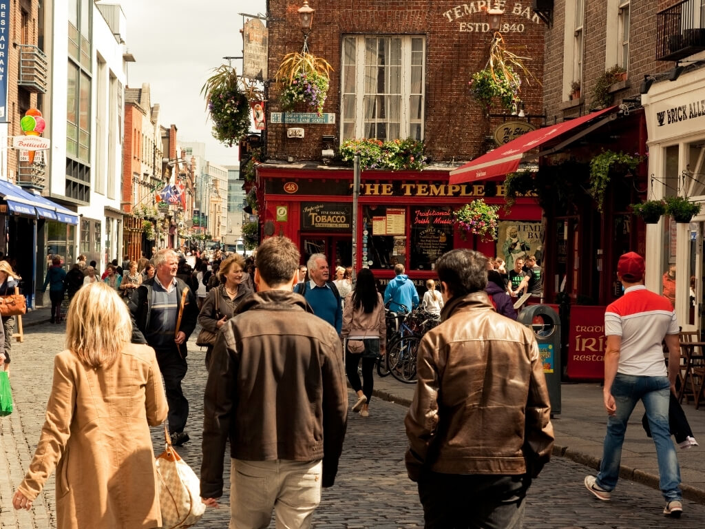 A picture of a busy street in Dublin's Temple Bar with people walking along the street and entering pubs