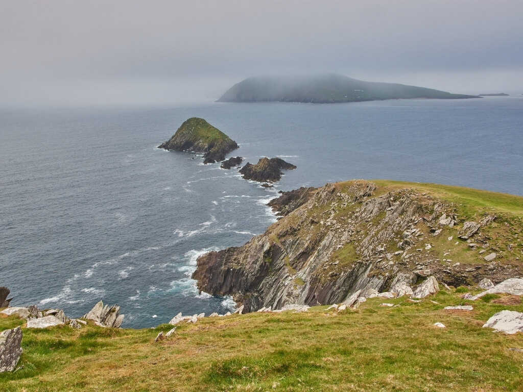 A picture of mist and stormy weather over an island off the rugged coastline of the Dingle Peninsula in Ireland