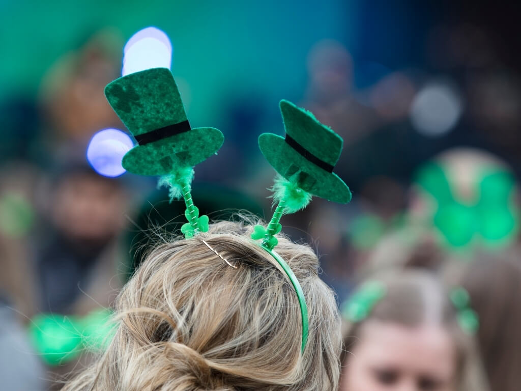 A picture of a headband on a woman's head with two green leprechaun hats on it for celebrating St Patrick's Day in Ireland