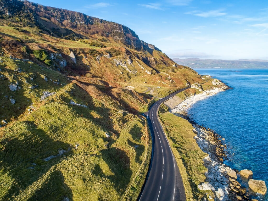 A picture of a road following a coastline, which is the Antrim Coast Road in Northern Ireland