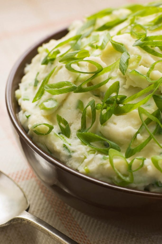 A picture of a bowl of Irish champ, made from mashed potatoes and spring onions