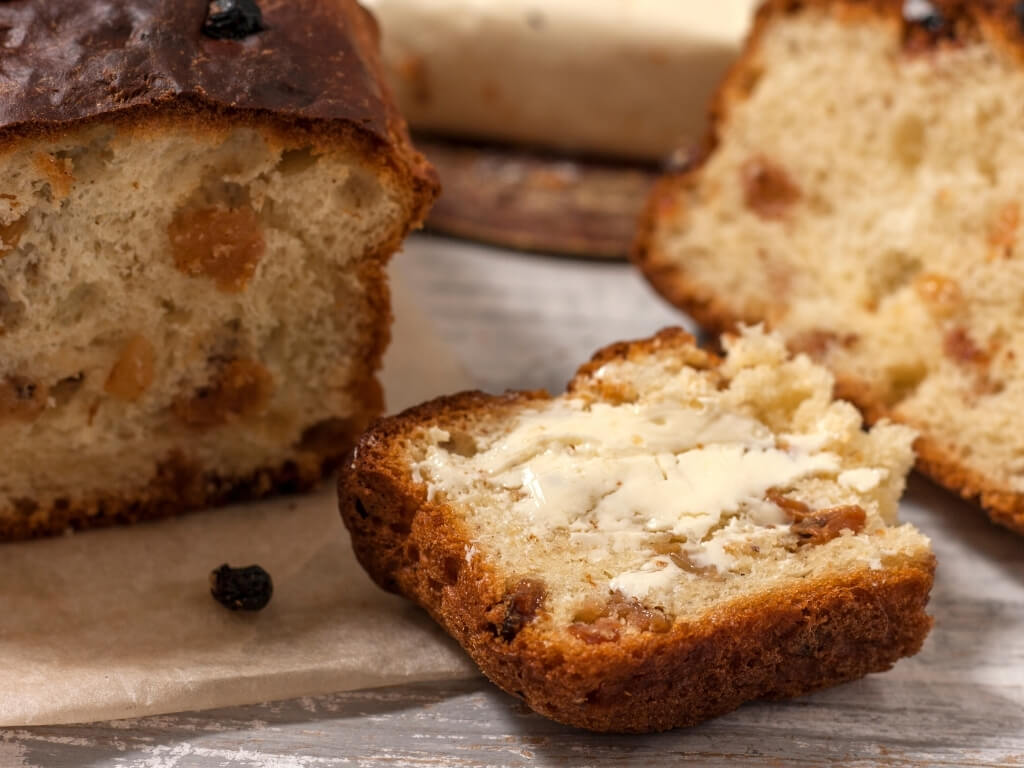 A picture of Irish Barmbrack, sliced with butter on it