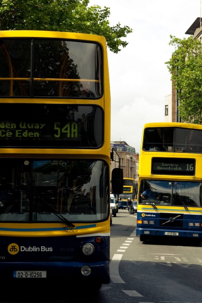 A picture of two Dublin buses, the number 16 and the number 54A travelling on a road in Dublin