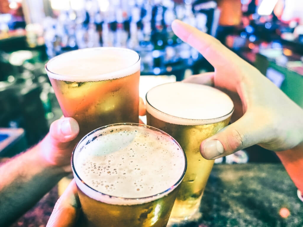 A picture of three pints of beers being clinked together to say Cheers