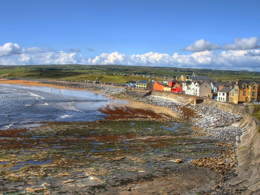 A picture of the stony shoreline with the tide out at Lahinch in County Clare