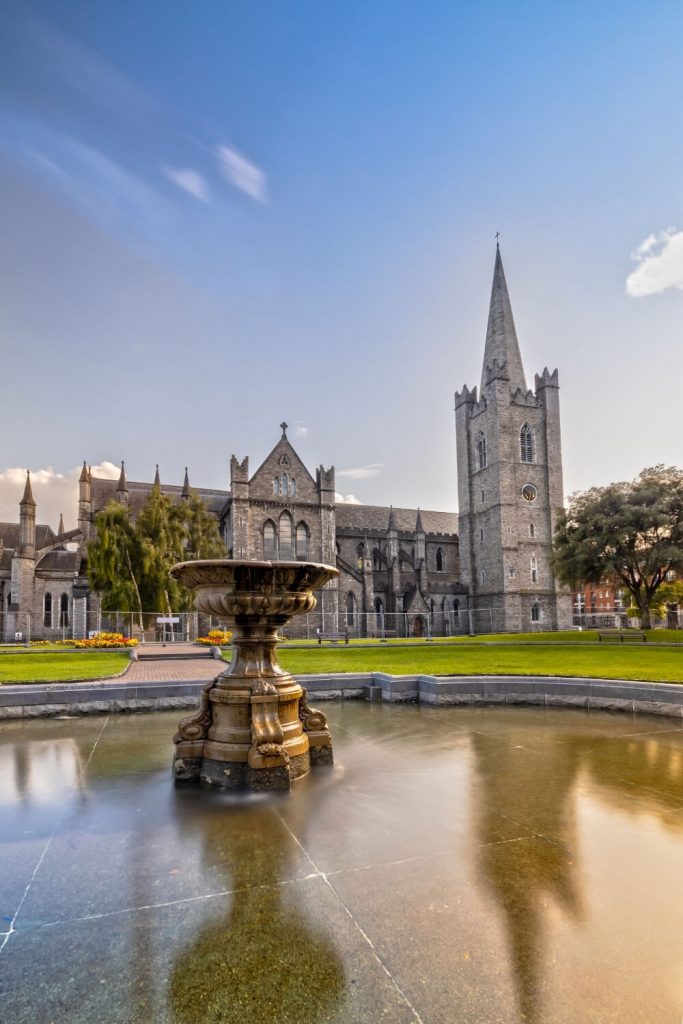 A picture of St Patrick's Cathedral Dublin with a fountain in front with blurred reflections of the cathedral in the water