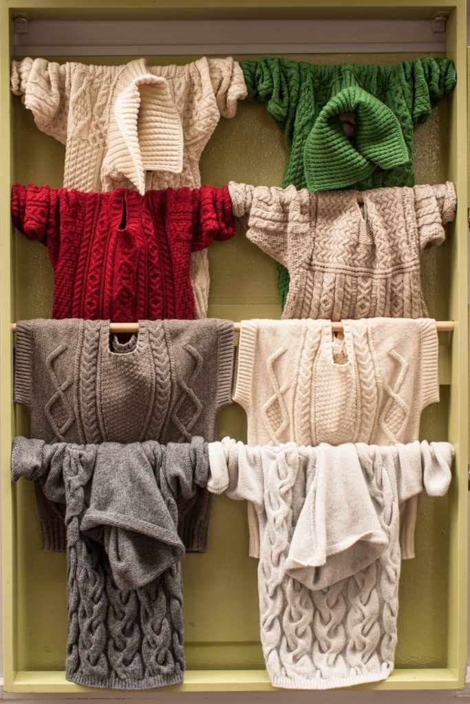 A picture of some clothes rails with Aran jumpers displayed on it