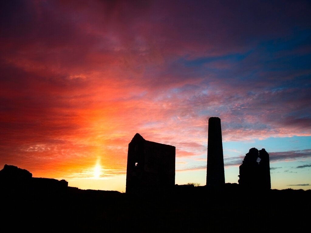 A silhouette picture of the ruined buildings of the Tankardstown Mine on the Copper Coast in Waterford