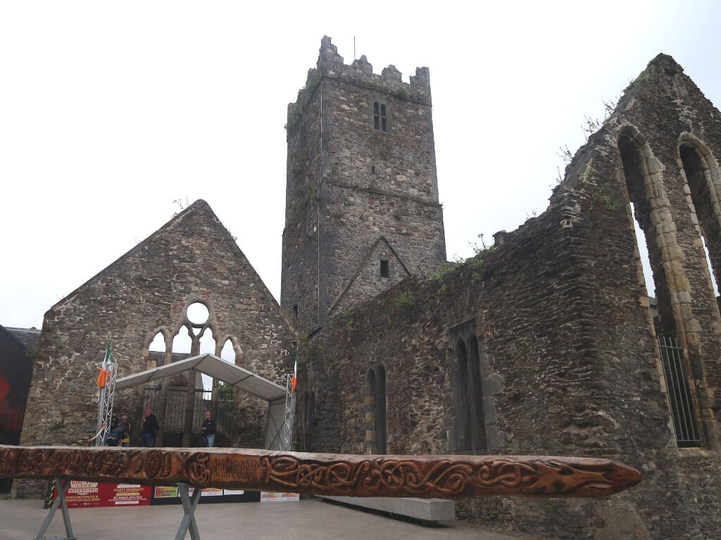 A picture of the ruins of a cathedral and a piece of carved Viking wood in Waterford City