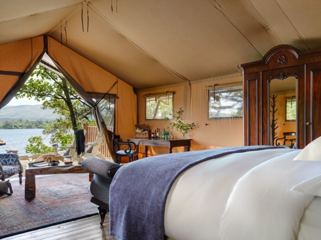 A picture of the interior of a safari tent, looking out at the shoreline at Dromquinna Manor Glamping, Kerry