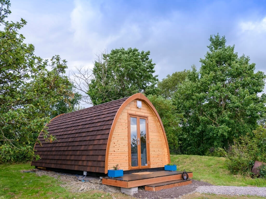 A picture of one of the glamping pods with trees behind it at Farmyard Lane Glamping