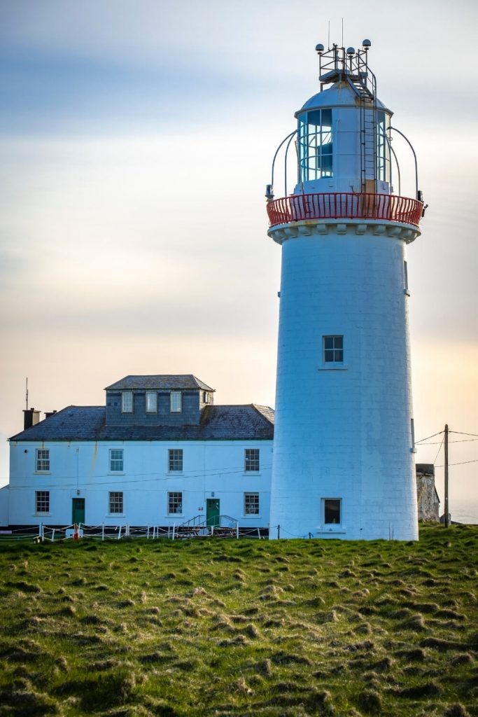 A picture of the white tower and side building of the Loop Head Lighthouse