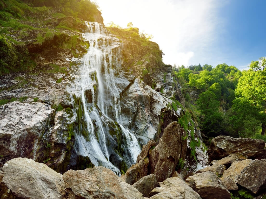 A picture of the water falling down the rockface of Powerscourt Waterfall, Ireland's tallest and one of the best waterfalls in Ireland