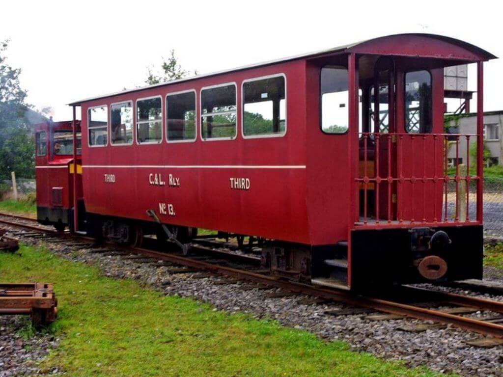 A picture of a red train carriage and engine at the Cavan & Leitrim Railway