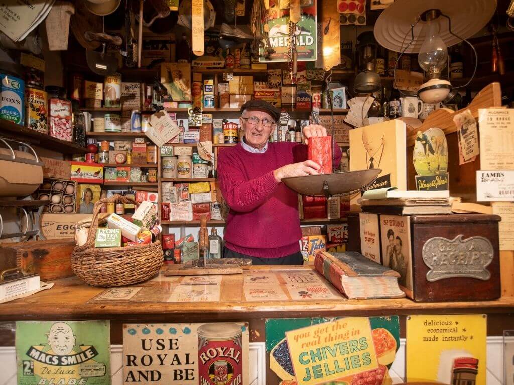 A picture of one of the owners of the Derryglad Folk Museum in the rural shop reconstruction