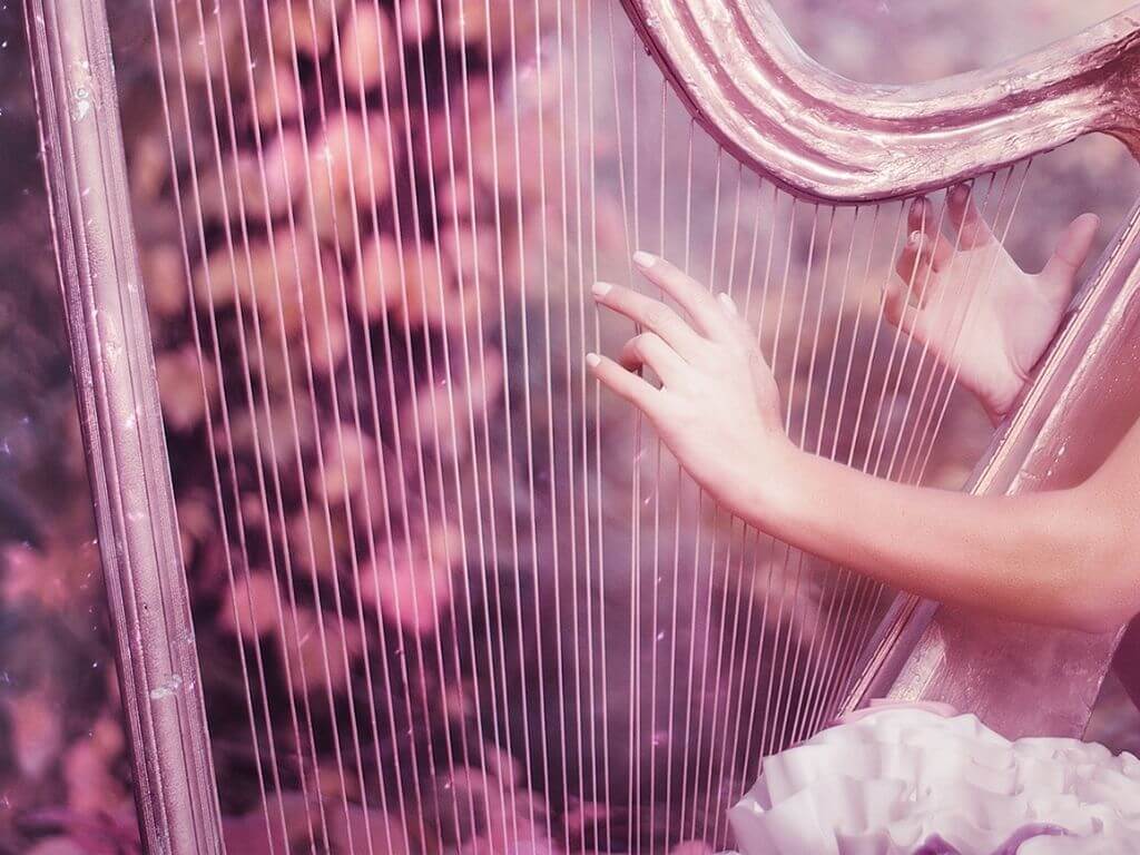 A picture of a set of hands (of a fairy) playing a harp symbolising the Aibell from Irish folklore