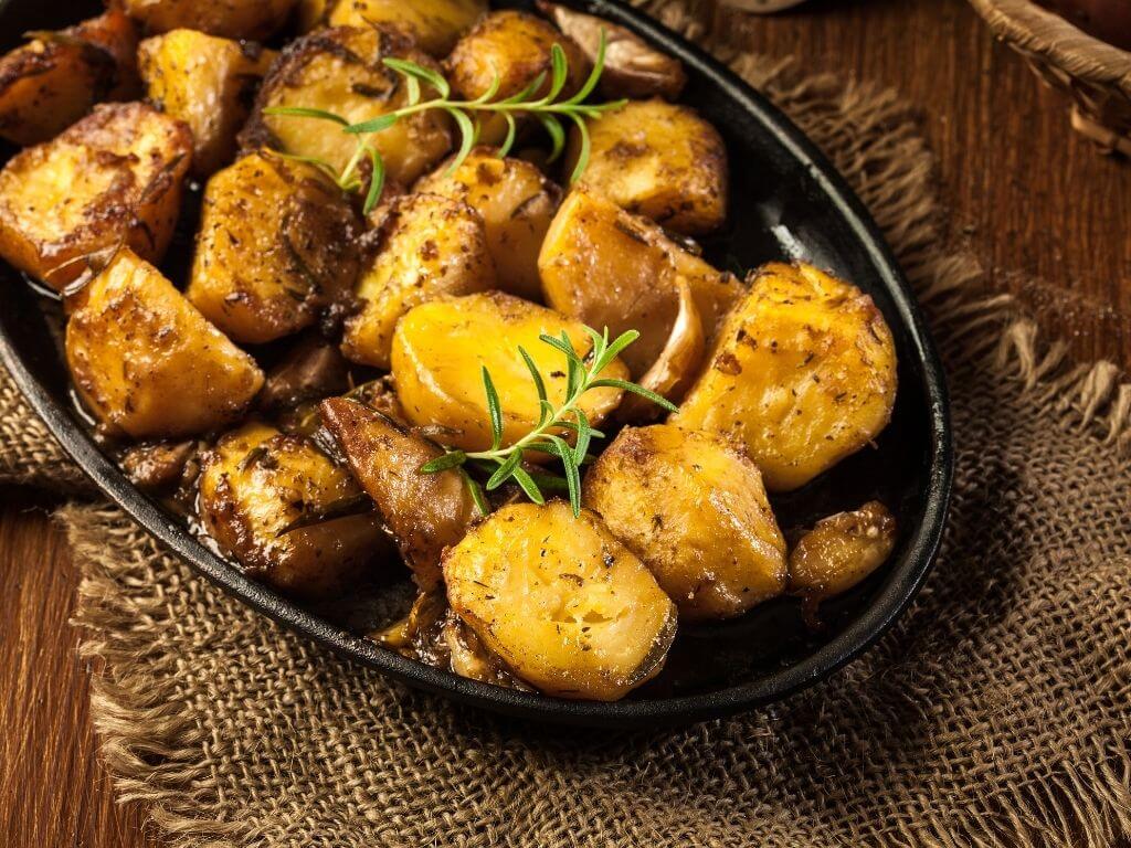 A picture of a roasting dish containing Garlic and Rosemary Roast Potatoes