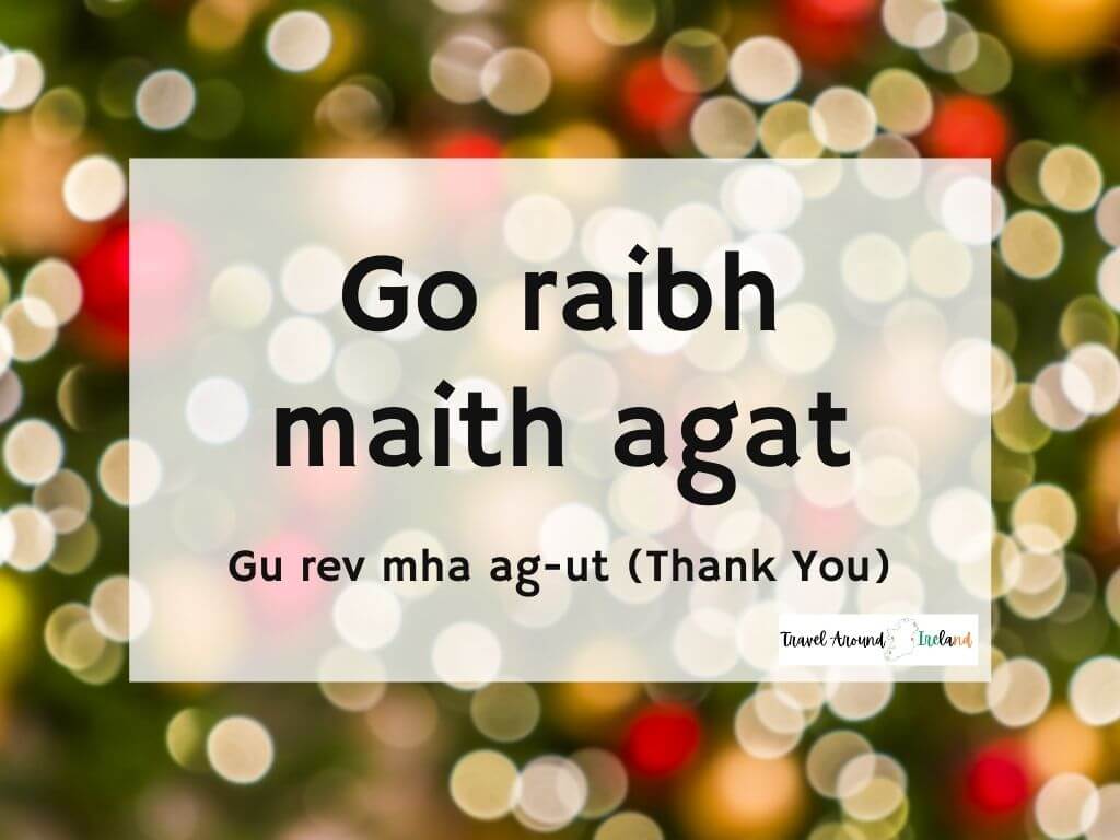 A picture with text over bokeh lights saying Go raibh maith agat meaning Thank you in Irish