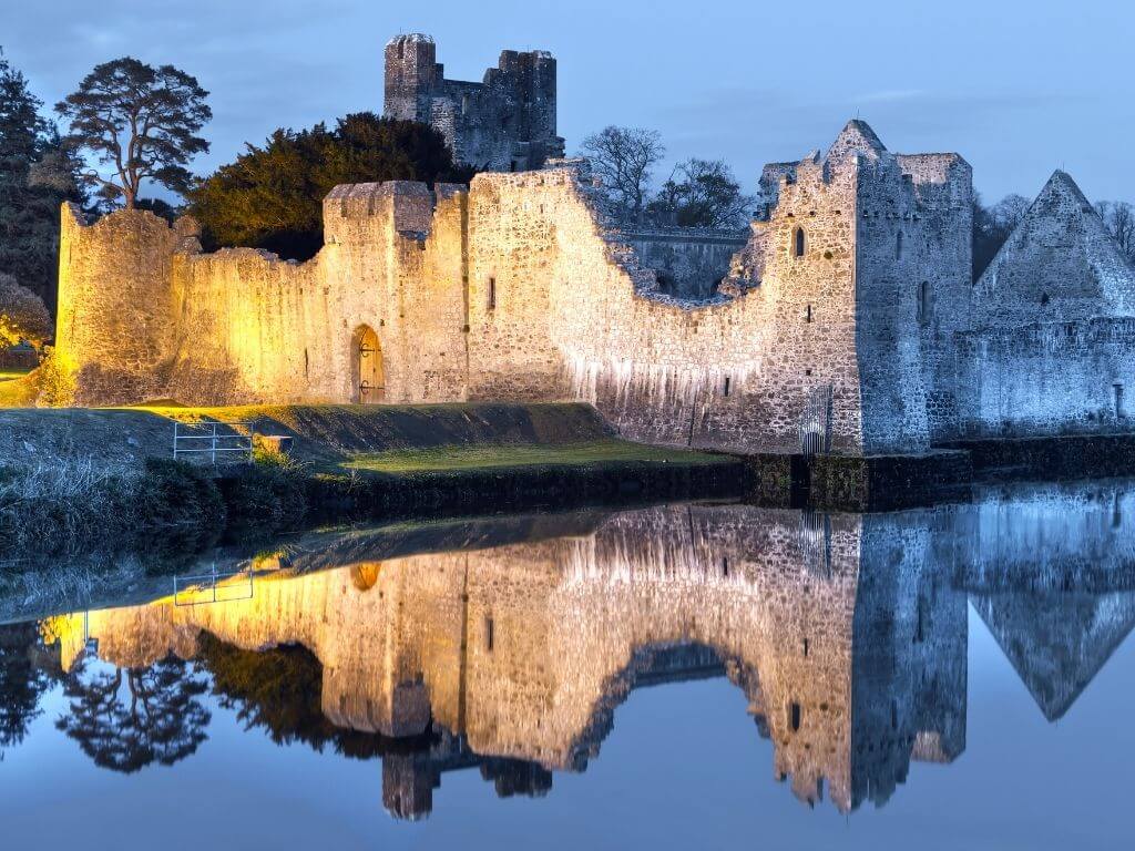 A picture of Adare Desmond Castle, Limerick with its reflection in the river water beside it