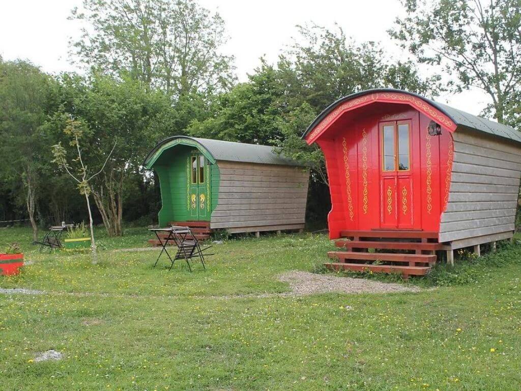 A picture of the red and green gipsy-style glamping wagons at Kitty's Cosy Camping