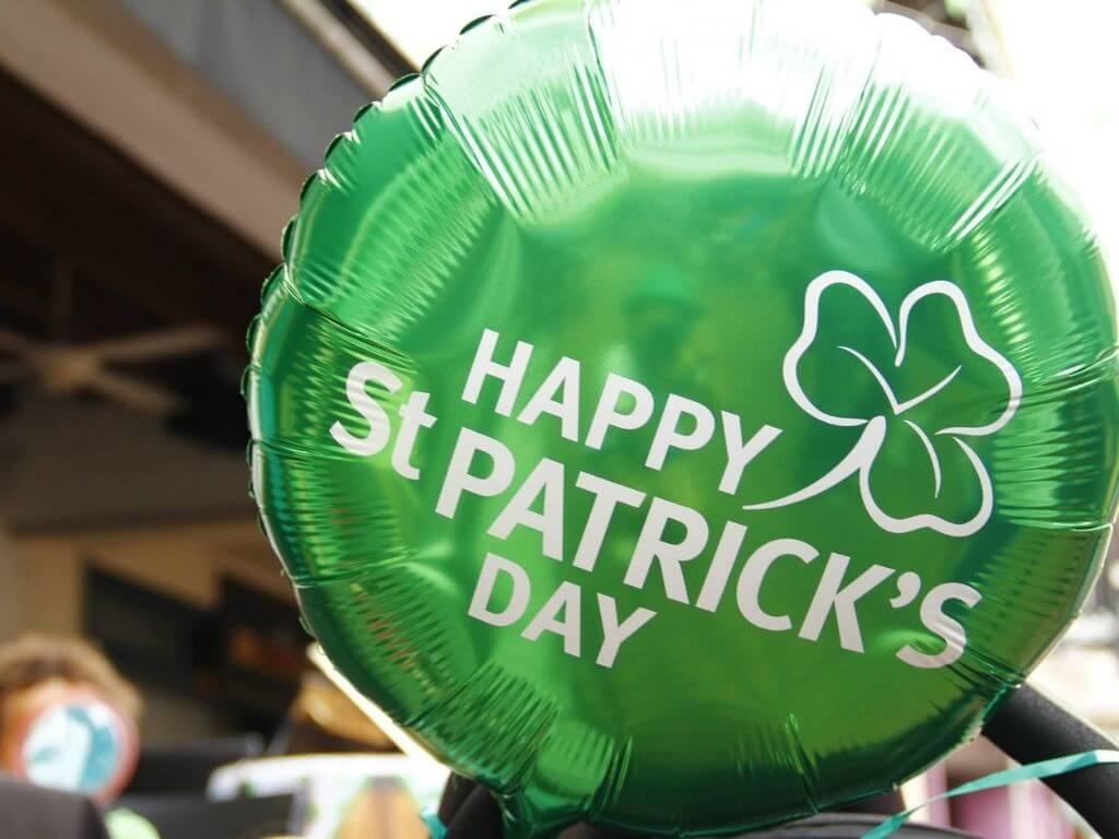 A picture of a green foil balloon with a shamrock and the words Happy St Patricks Day on it