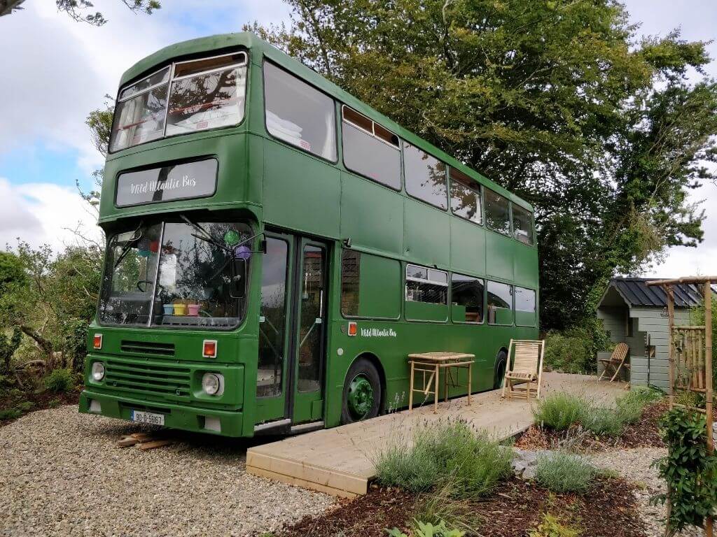A picture of the exterior of the green Wild Atlantic Bus Glamping bus
