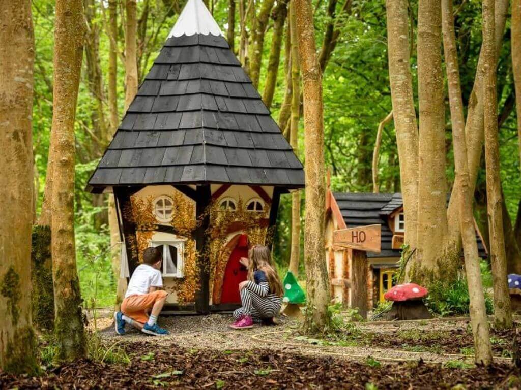 Children in a forest, peering into an elf house at Castlecomer Discovery Park