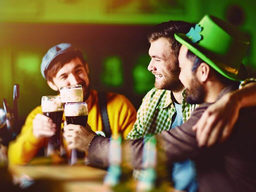 A group of three men toasting St Patrick's Day in a pub