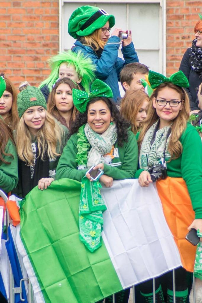 A group of ladies in green outfits at the fencing, waiting for the start of the St Patrick's Day Parade, Dublin