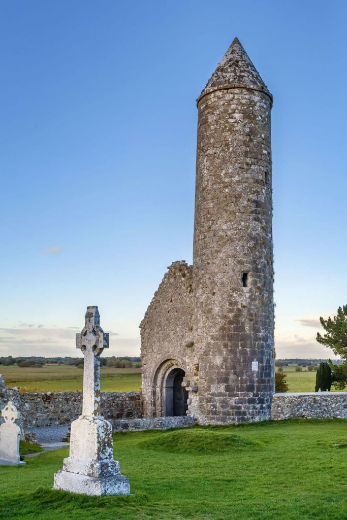 A picture of one of the round towers and high crosses at Clonmacnoise in County Offaly, Ireland