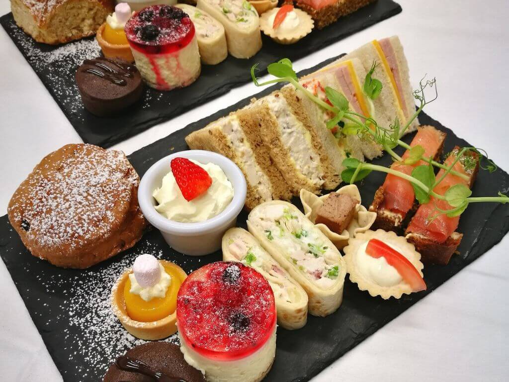 Two slate plates set with different foods on a table for the Oranmore Lodge Hotel afternoon tea