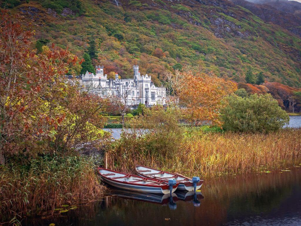 A picture of Kylemore Abbey in autumn across the lake in front of the abbey