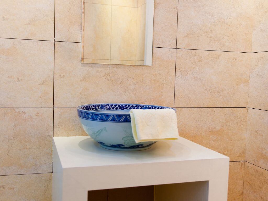 A picture of a white washcloth hanging over a sink unit in a bathroom