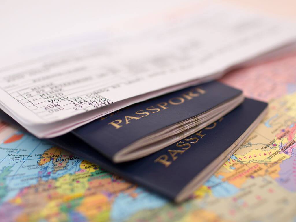 A picture of two passports and boarding cards on top of a map