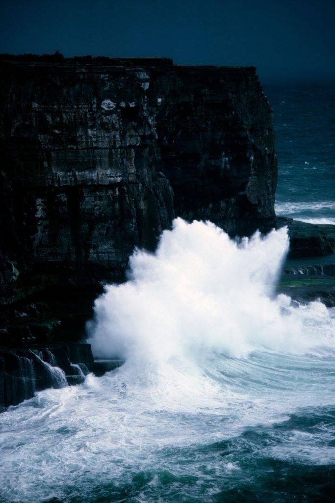 A picture of stormy waves crashing against the cliffs at Dun Aonghasa on the Aran Islands