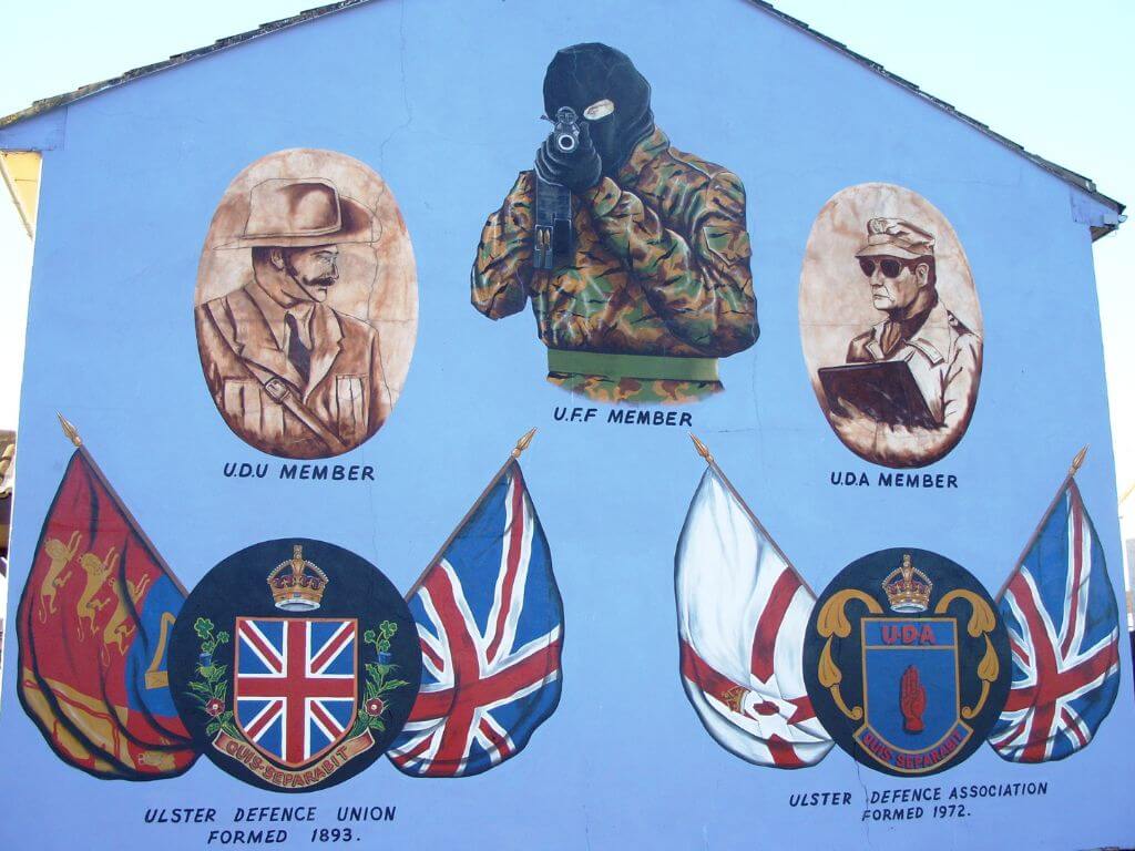 A picture of different murals on the side of a wall in Belfast from the times of the 'Troubles'