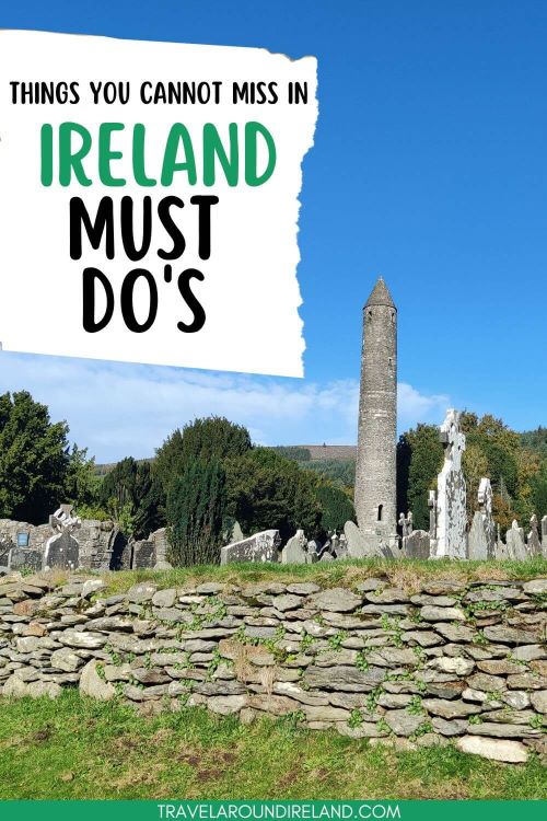 A picture of the Round Tower at Glendalough and headstones in the graveyard in front, blue skies overhead, green grass in the foreground and text overlay sating things you cannot miss in Ireland, must-dos