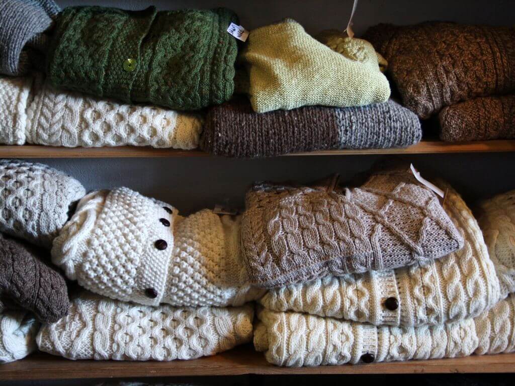 A picture of two shelves containing woollen winter jumpers