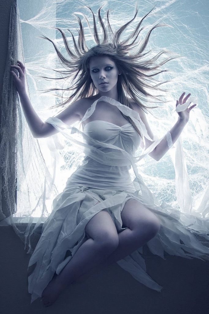 A picture of a young lady dressed in white and her hair standing up as if blown by the wind to depict one image of the Banshee