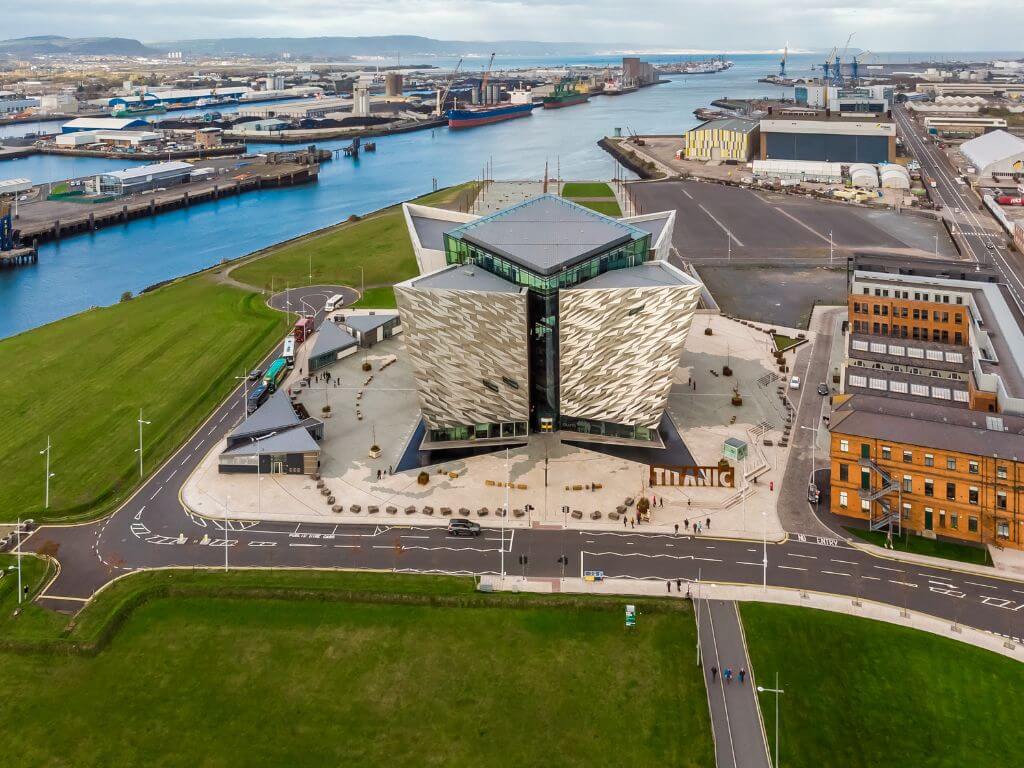 An aerial shot over the Titanic Museum in Belfast's Titanic Quarter with the River Lagan in the background and the docklands to the left of the picture