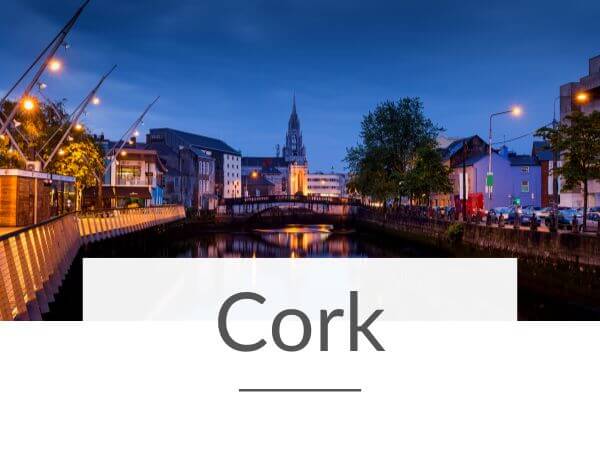 A picture of Cork City surrounding the River Lee at night and text overlay underneath saying Cork
