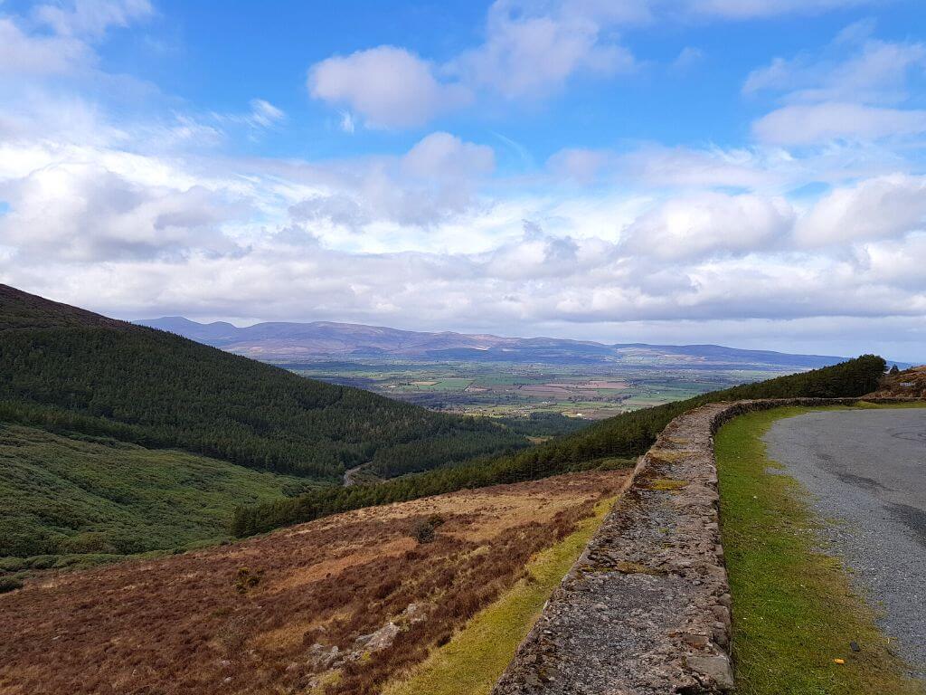 A picture from the roadside on a road on the Tipperary-Waterford border across a valley with foresty hills to the left.