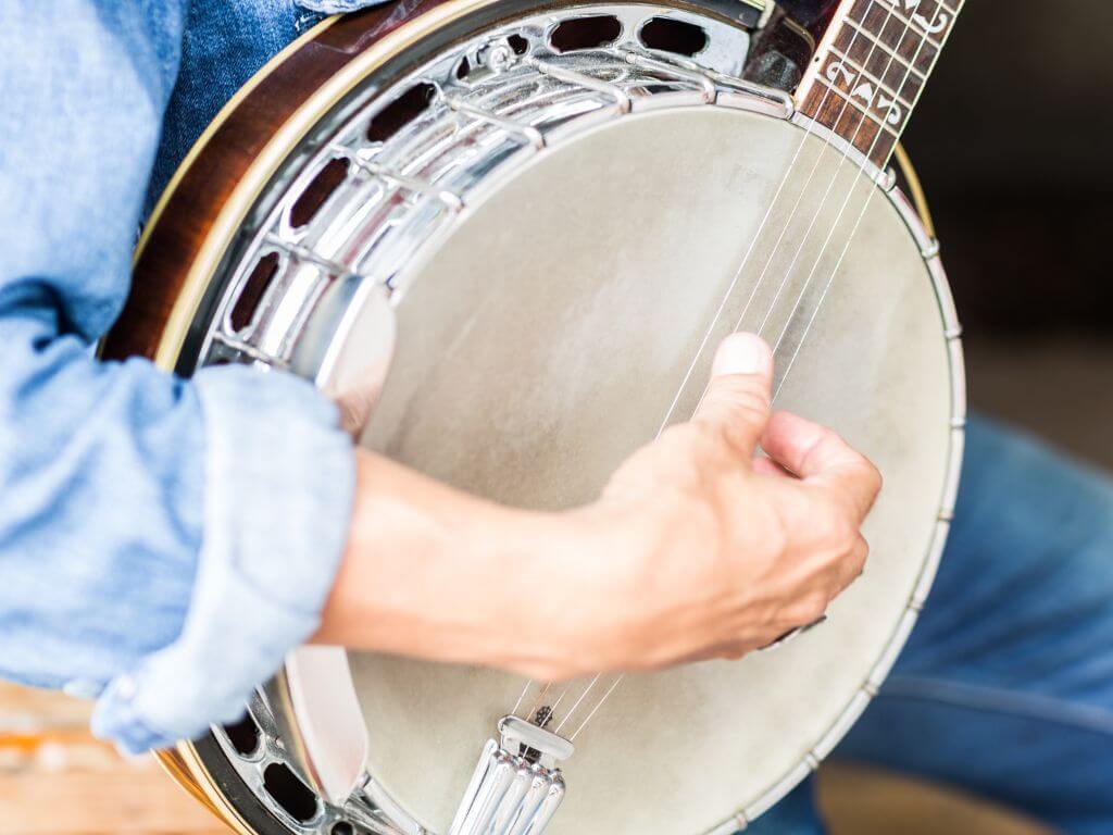 A picture of a man's hands playing a banjo