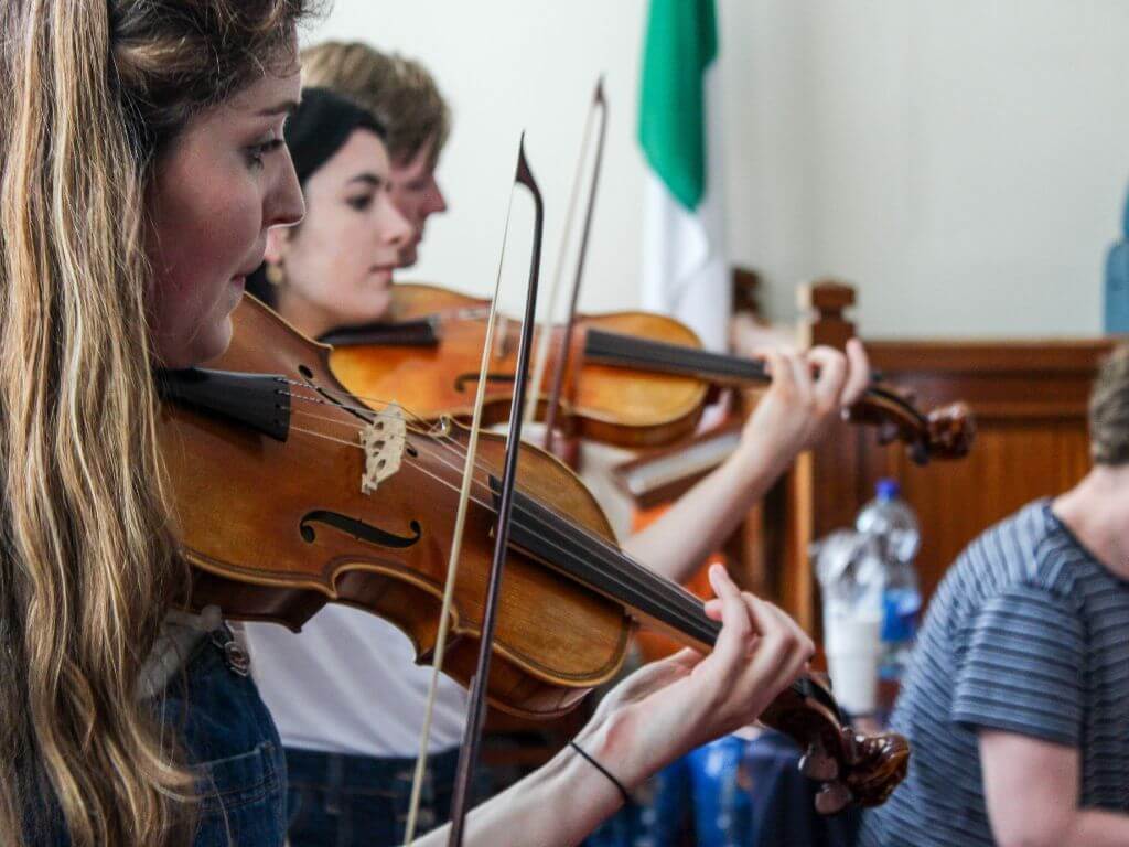 A picture of some people playing violins at the West Cork Chamber Music Festival