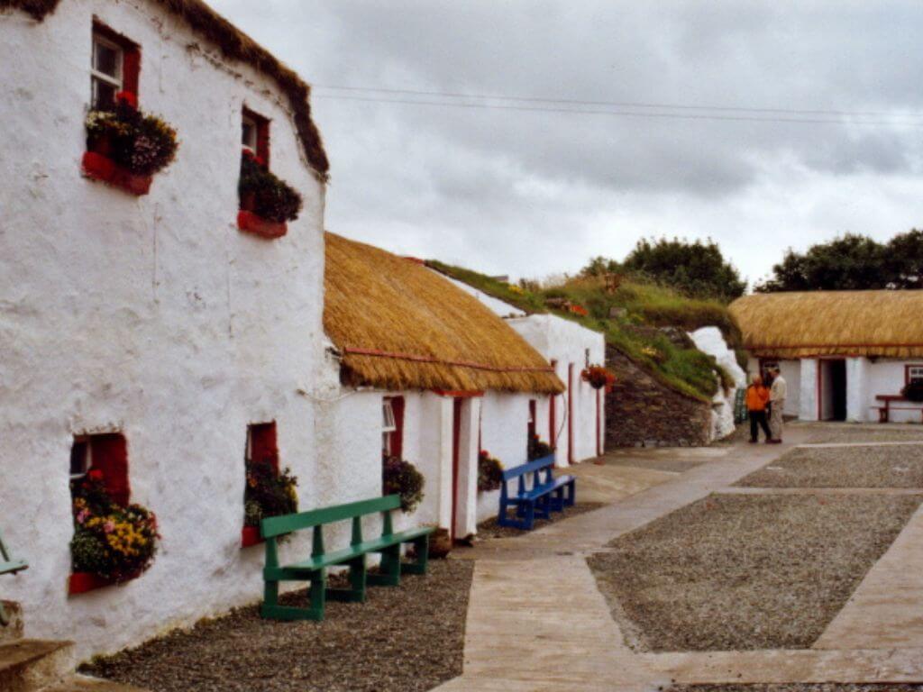 A picture of the Doagh Famine Village, Donegal with some thatched roofs on the dwellings