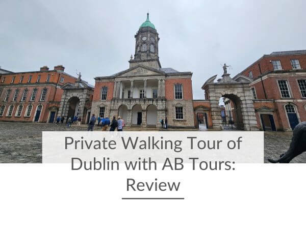 A picture of the courtyard in Dublin Castle with people crossing it, on a rainy day and text underneath saying private walking tour of Dublin with AB Tours: review.