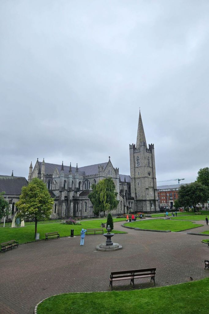 A picture of St Patrick's Cathedral in Dublin, Ireland with grey skies overhead and St Patrick's Park in the foreground