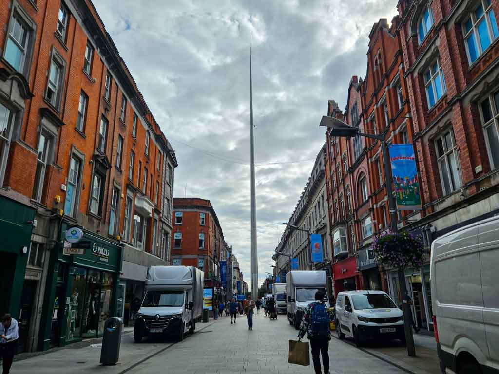 A picture of the Spire on O'Connell Street, taken early in the morning from Henry Street with the street lined with white vans doing deliveries before the street becomes pedestrianised again.