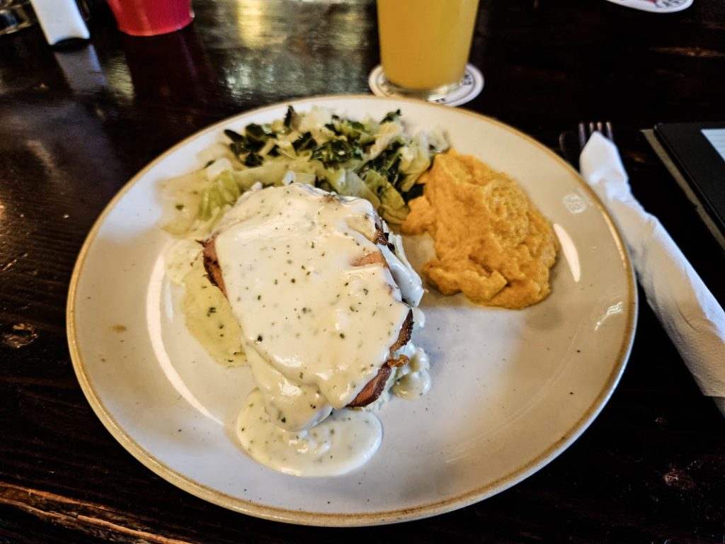 A picture of a plate of ham, cabbage and mashed potato served with parsley sauce in The Brazen Head pub in Dublin.